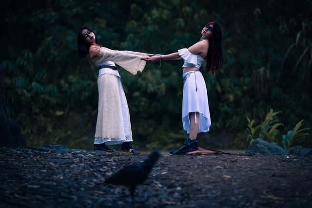 Dos modelos vestidas de blanco en un bosque al anochecer — serie Brujas